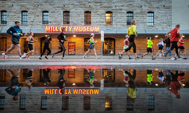 Runners pass the Mill City Museum at the Medtronic Twin Cities Marathon