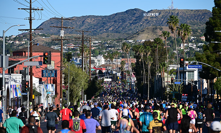 Los Angeles Marathon runners on Sunset Blvd with the Hollywood sign in the distance
