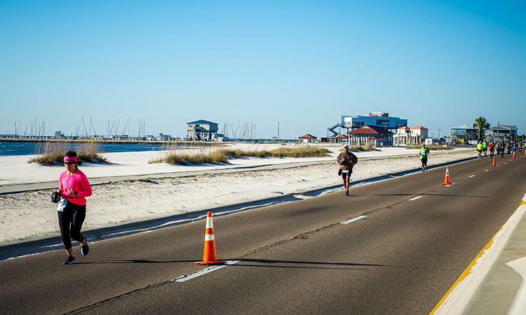 Runners run alongside the Gulf of Mexico at the Mississippi Gulf Coast Marathon