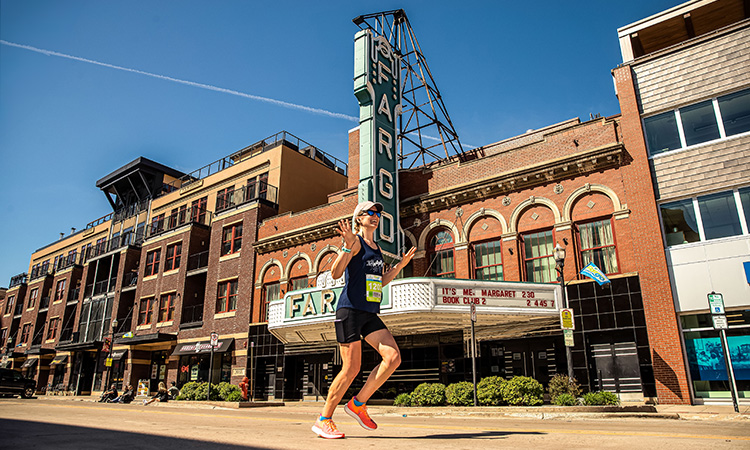 Runner passes the Fargo Theatre at the 2023 Fargo Marathon