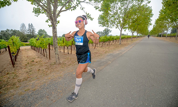 Runner crosses a vineyard at the Santa Rosa Marathon