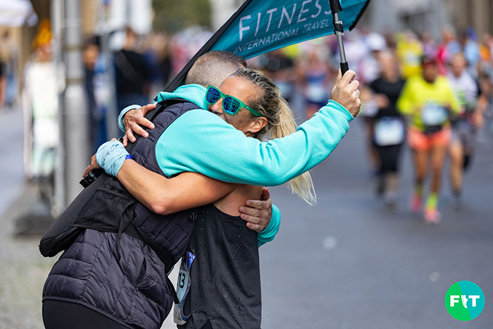 Runner embraces a Fitness International Travel team member at the Berlin Marathon