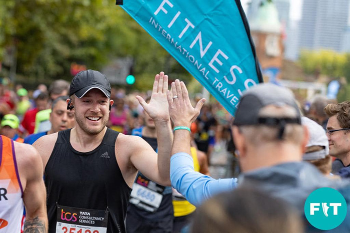 Runner high-fiving spectators at the London Marathon