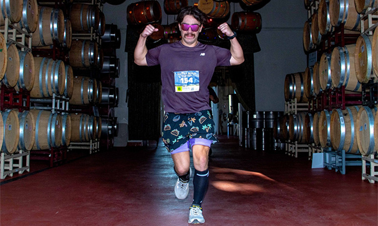 Participant runs through the DeLoach Vineyards barrel room at the Santa Rosa Marathon
