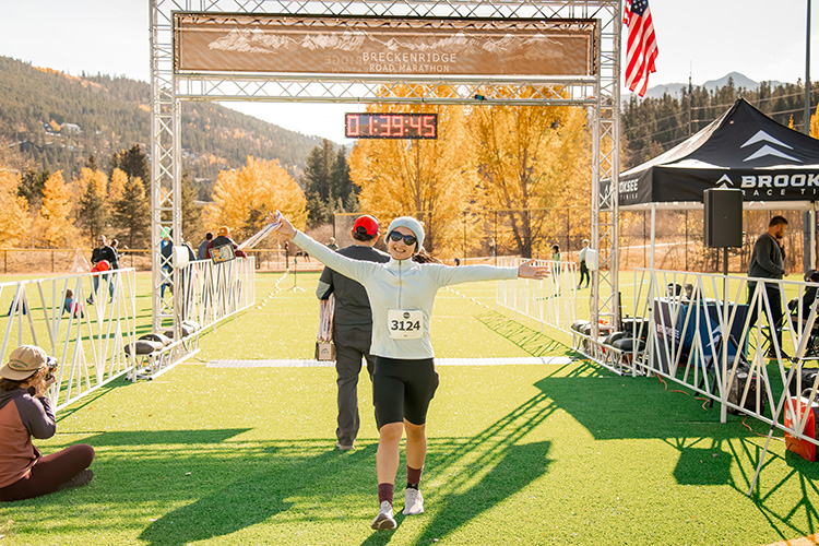 Happy runner crossing the finish line at the Breckenridge Road Marathon