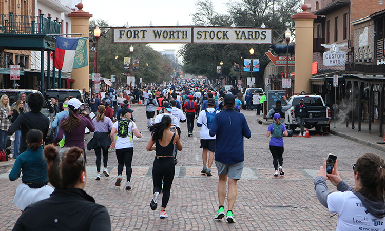 Runners pass the Fort Worth Stockyards at The Cowtown Marathon