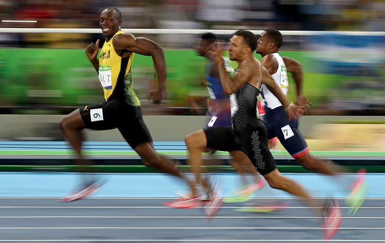 Usain Bolt smiling during a race at the 2016 Rio Summer Olympics