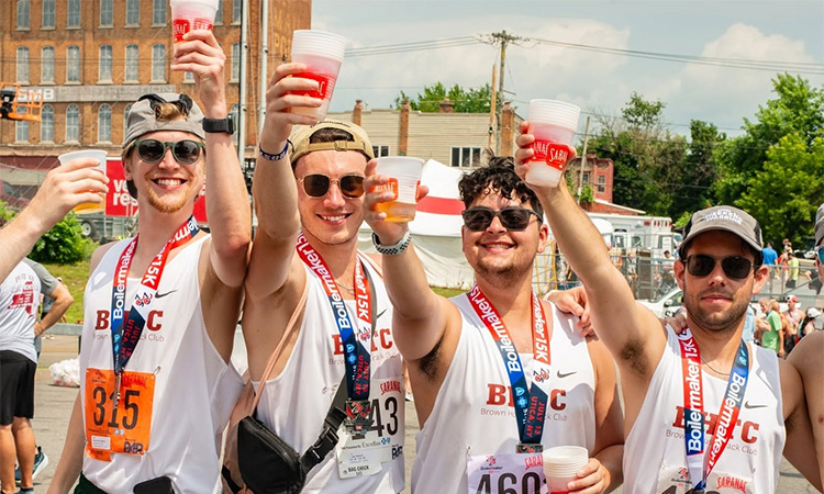 Finishers raise a toast to celebrate at the finish line of the 2025 Boilermaker Road Race